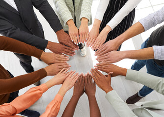 Unknown multiracial men and women folded their arms in circle as symbol of friendship and...