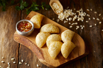 Empanadas de morocho, a typical ecuadorian dish served with chilli and on a wooden and traditional background. 