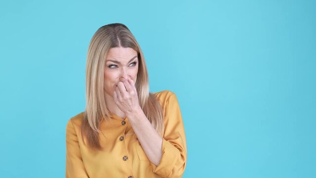 Lady cover fingers nose breath awful taste isolated blue color background