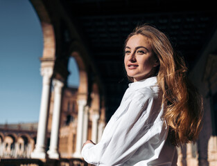 Dreamy young woman enjoying sightseeing in Seville, Spain