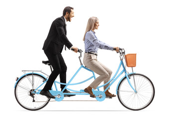 Young man and woman in formal clothes riding a tandem bicycle