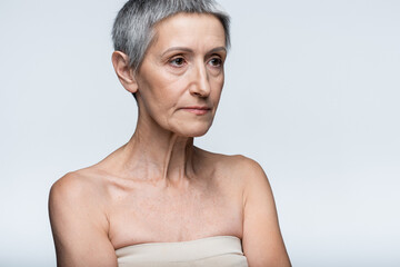 middle aged woman looking away isolated on grey