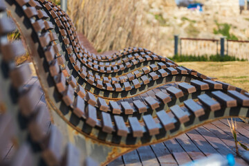 Comfortable sun loungers made of wood against the backdrop of a city park. The concept of a relaxing holiday