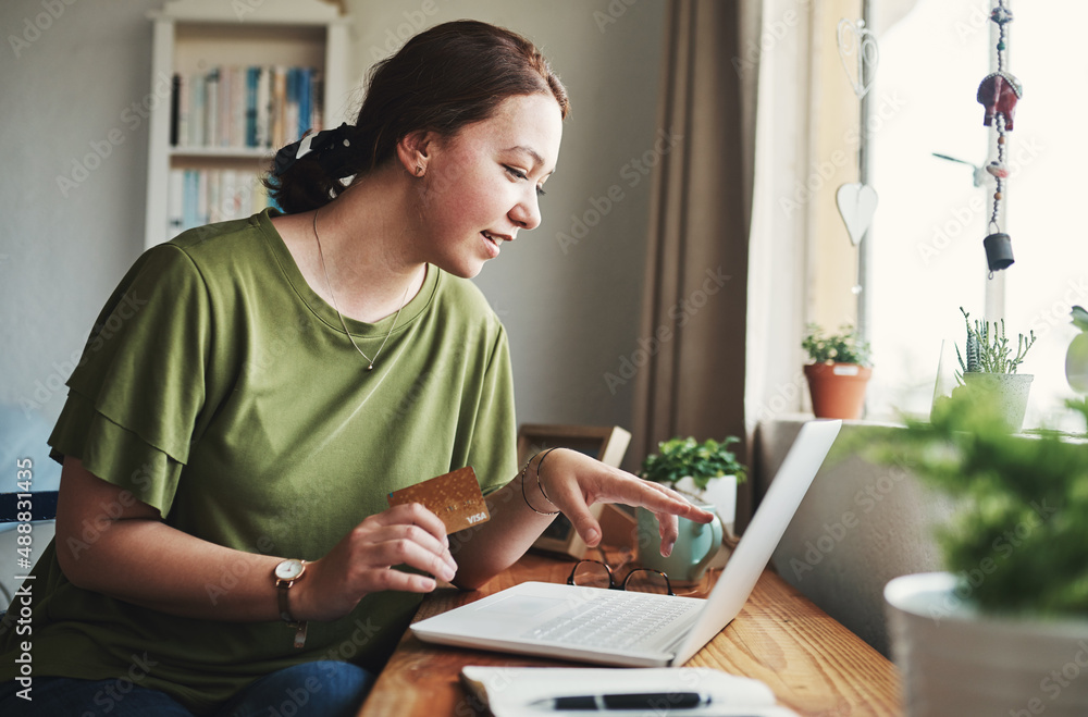 Poster This is exactly what I need. Cropped shot of an attractive young businesswoman sitting alone in her home office and using her laptop for online shopping.