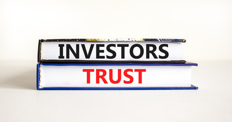 Investors trust symbol. Concept words Investors trust on books on a beautiful white table white background. Business invest and investors trust concept, copy space.