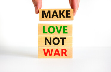 Make love not war symbol. Concept words Make love not war on wooden blocks. Businessman hand. Beautiful white table white background. Make love not war business concept. Copy space.
