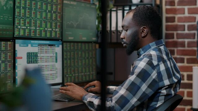 Male investor using forex exchange fund sales on multiple monitors, planning stock market profit growth. Financial investment share with numbers, capital trading money on graphs. Tripod shot.