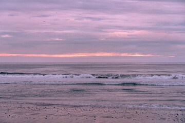 Pacific Ocean waves breaking onto the California coast at sunset
