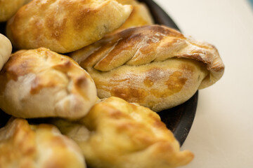 Delicious little pies with green onion and egg. Traditional Russian cuisine. Homemade cakes. Pies on a wooden board.
