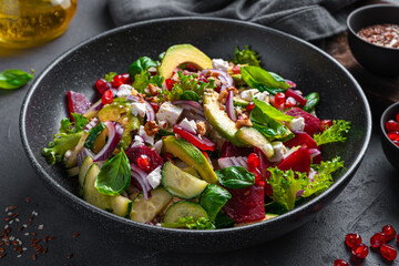 Vegetable salad with avocado, beetroot, cucumber and feta cheese seasoned with pomegranate, sesame and flax seeds and nuts.