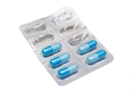 Blister of blue pills on white background