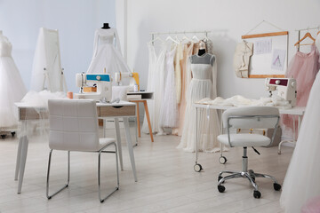 Dressmaking workshop interior with wedding dresses and equipment