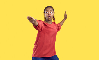 Portrait of funny young woman standing in martial arts pose isolated on bright yellow background....