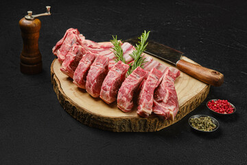 Raw lamb rib roast on wooden slab