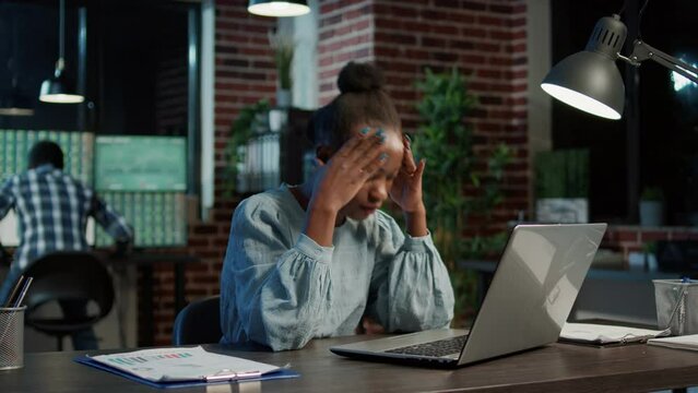 Disappointed woman making exchange market mistake, using laptop to plan financial investment at night. Trading stock prices and sales to create hedge fund profit, feeling stressed.