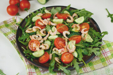 Healthy vegan salad of smoked shrimps, cherry tomatoes, cucumber and mixed leaves. Healthy eating concept. Detox diet. Vegetarian lunch. Weight loss, top view.