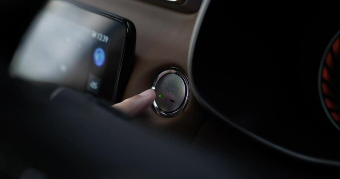 Close up of Man presses start button in car motor. Turning on functioning systems vehicle. Start using car before driving, start electronic systems in car.