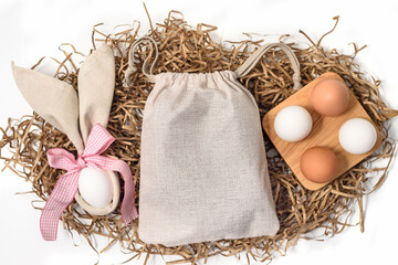 Easter mockup gift sack tote with bunny and easter eggs on white background. Flat lay, top view, copyspace.