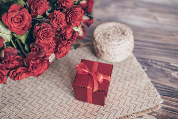 the concept of the holiday. gift in red box and bouquet of roses