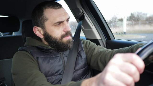 Handsome bearded adult man driving a car