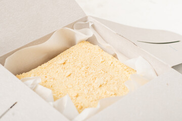 Napoleon cake in a cardboard box. Sweet gift. Delivery of confectionery.