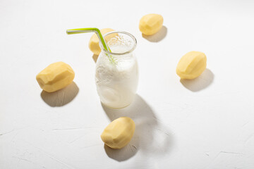 Potato milk concept. Bottle with potato milk on a white background. An alternative to animal products. Vegan food.
