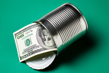 Dollars in an open tin can. Safeguarding cash, stash concept. Time to get the deferred, accumulated money. Green background.