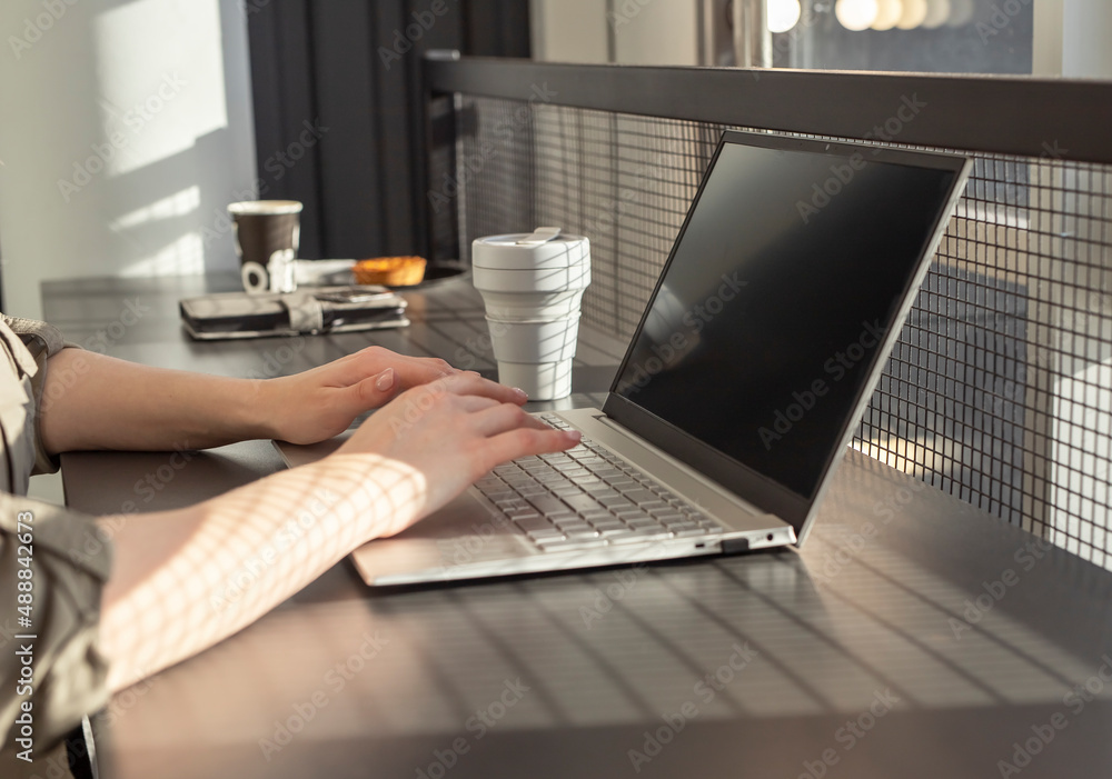 Aufkleber female hands closeup typing text on laptop keyboard. woman sitting at cafe table with computer and c