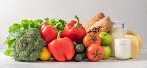 Healthy vegetables, fruits, green salad on the table. Grocery set of broccoli, lettuce, sweet red pepper, tomatoes, cucumbers, apples, lemon. The concept of organic, fresh food, grocery delivery