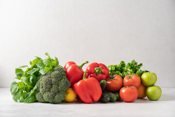 Healthy vegetables, fruits, green salad on the table. Grocery set of broccoli, lettuce, sweet red pepper, tomatoes, cucumbers, apples, lemon. The concept of organic, fresh food, grocery delivery