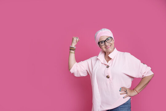 Cheerful sick woman showing bicep for positive attitude