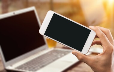Male hand holding a smartphone with a blank screen