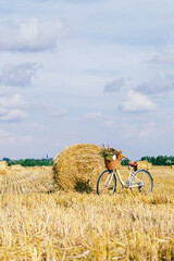 Bicycle standing in a field among harvest of wheat