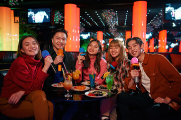 Karaoke together with friends and enjoying time in karaoke club,