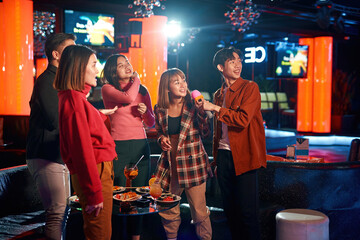 Asian clubbers rocking and chilling out in karaoke club