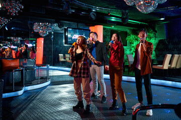 Asian band singing and dancing at karaoke party