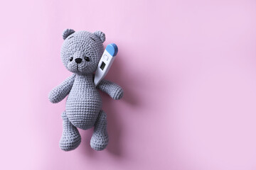 Toy bear with thermometer on pink background, top view. Space for text