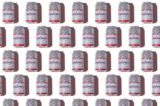 Budweiser american beer cans pattern with hard shadow on white background. Alcohol, brewery, industry, factory and bar concept.