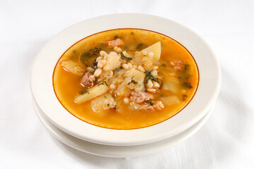 meat soup with potatoes, beans, leek and vegetables, bowl of soup or broth on white background