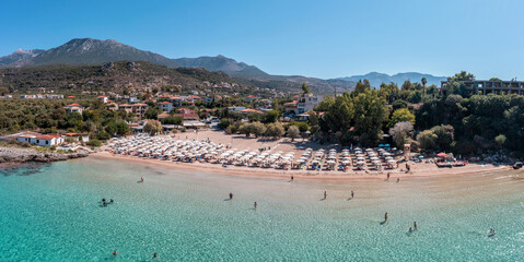 Greece, sandy beach, aerial drone view. People swim and relax at Stoupa beach Mani, Peloponnese.