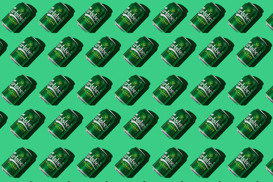 Pattern of green Heineken Dutch beer cans with hard shadow on white background. Alcohol, brewery, industry, factory and bar concept.