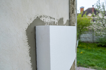 Installation of styrofoam insulation sheets on house facade wall for thermal protection