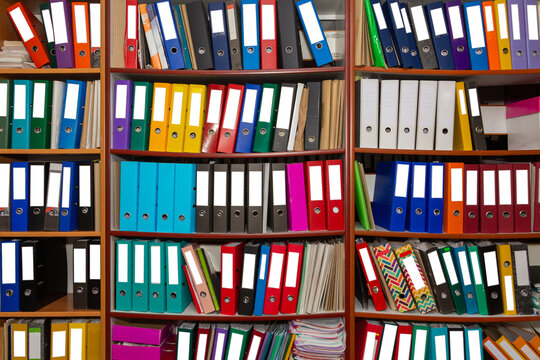 Colorful ring binder folder on wooden shelves, office stationary.