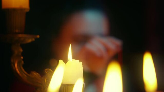 Experienced witch searching for person, candle light, magic ritual, divination
