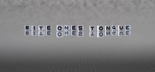 bite one's tongue word or concept represented by black and white letter cubes on a grey horizon...