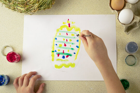 child draws an easter drawing on a white sheet