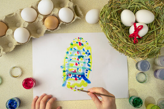 child draws an easter drawing on a white sheet