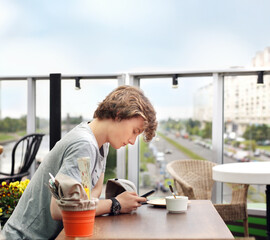 Lifestyle portrait of a young man using a smart phone outdoors