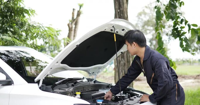 Asian automobile mechanic check engine oil level. Service maintenance insurance with car engine. Car service concept.