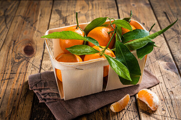 Fresh organic Tangerines, mandarins in wooden box from supermarket. Wooden background. Top view
